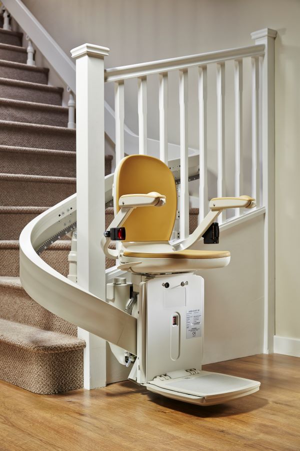 A staircase with a curved stair lift attached to it. The stairlift is an Acorn 190 Curved Stairlift, a high quality stailift. 